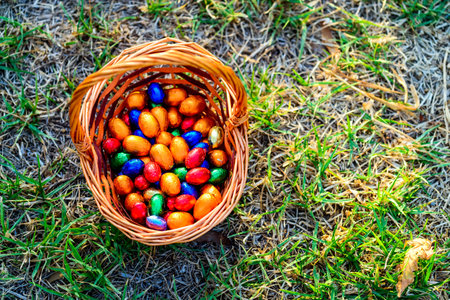 Colorful chocolate eggs in basket on grass
