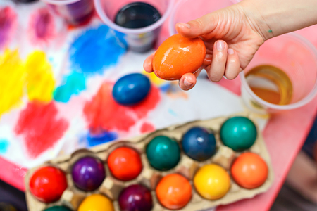 Child holding freshly boiled and colored Easter egg in his handの写真素材