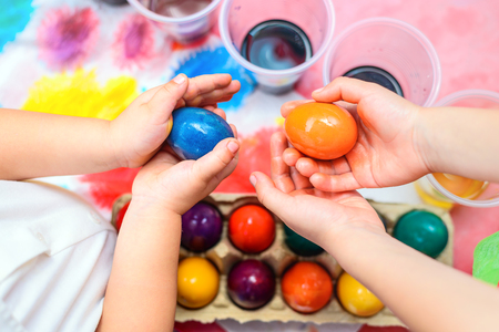 Child holding freshly colored Easter egg in his handsの写真素材