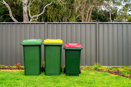 Australian home rubbish bins set provided by local council on back yard in Australian suburbの写真素材