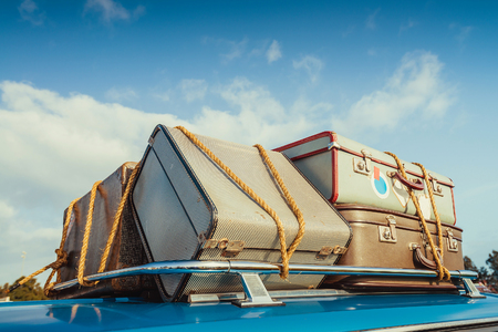 Pile of vintage bags on roof of the travel car fastened with ropeの写真素材