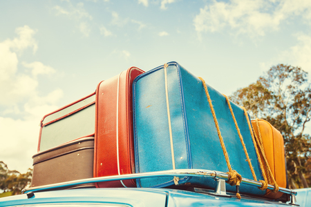 Pile of vintage bags on roof of the travel car fastened with ropeの写真素材