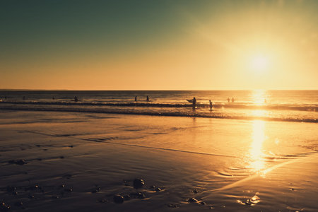 People swimming in the ocean at sunset, Moana beach, South Australia