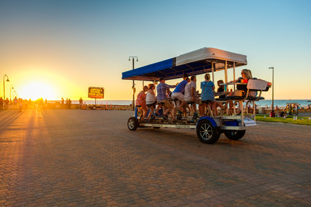 Adelaide, South Australia - March 18, 2017: Glenelg Pedal Bar with people having fun on the move at sunset timeのeditorial素材
