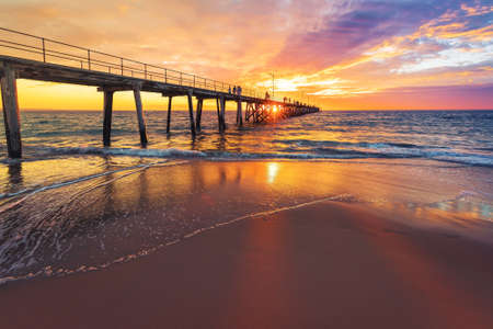 Port Noarlunga beach pier with people walking along at sunset, South Australiaの写真素材