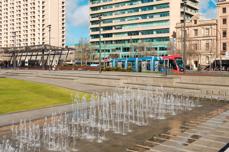Adelaide City, South Australia - August 19, 2019: Victoria Square fountain on a bright day with Adelaide Metro tram driving past in the backgroundのeditorial素材