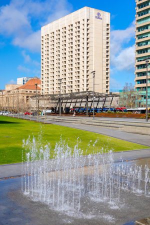 Adelaide City, South Australia - August 19, 2019: Victoria Square fountain on a day with Hilton Hotel in the background viewed on a bright dayのeditorial素材