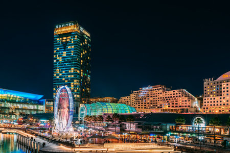 Sydney, Australia - April 16, 2022: Illuminated Sofitel and Novotel hotels viewed across Darling Harbour from Pyrmont Bridge at night timeのeditorial素材
