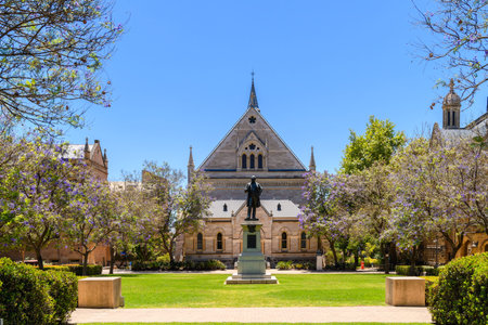 Adelaide, South Australia - December 28, 2022: University of Adelaide city campus building with a monument and jacaranda tree blossoms viewed across Goodman Crescent on a dayのeditorial素材