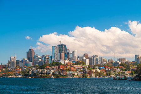 Sydney, Australia - April 17, 2022: Sydney city urban skyline view from departing ferry with blue sky and white clouds in the background on a bright dayのeditorial素材
