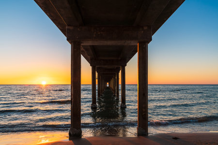 View from down under Brighton Jetty while standing on beach during sunset on summer evening, South Australiaの写真素材