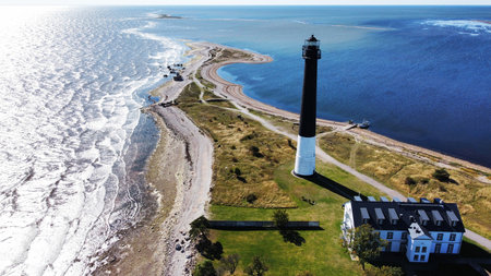 Aerial View of Majestic Lighthouse Standing on a Narrow Coastal Peninsula in Estoniaの写真素材