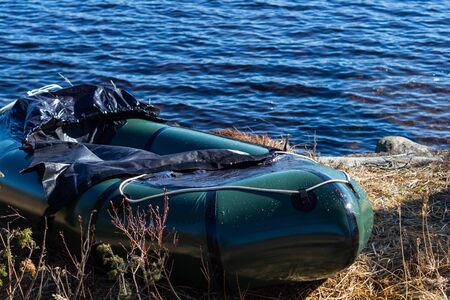 Packraft in the grass besides a lake on a sunny dayの写真素材