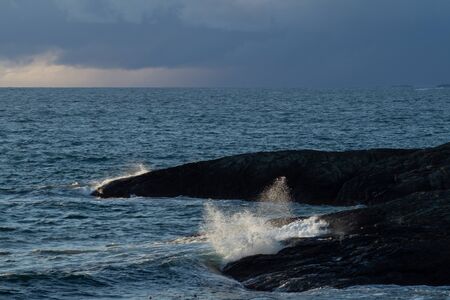 Waves hitting coastline on cloudy dayの写真素材