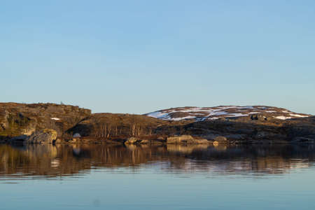 Mountain lake with snow on mountains with blue skyの写真素材