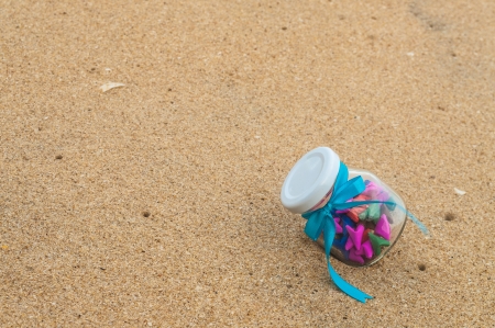 Paper heart in a glass bottle. Placed on the sand recycled paper craft fold.の写真素材