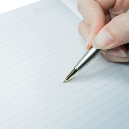 Silver pen writing on a white book.の写真素材