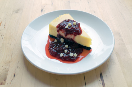 Strawberry Cheesecake on white plate placed on a wooden table.の写真素材