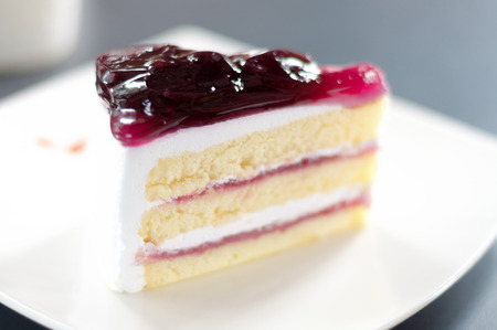 Blueberry cake on a white plate on the black table.の写真素材