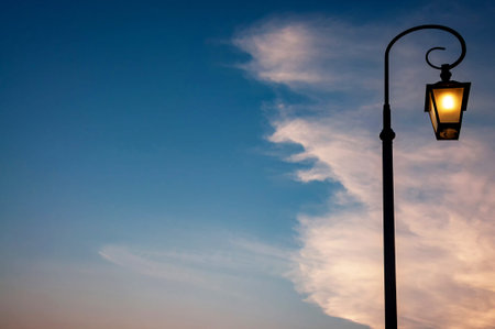 Retro style street lamppost at twilight against cloud and blue sky