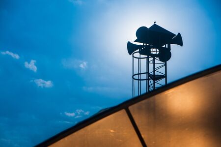 Silhouette vintage horn speaker for public relations, megaphone with clear blue sky over orange glass house.の写真素材