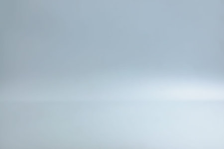 Blurred blank grey gradient background for product display. Grey backdrop on floor in empty studio...