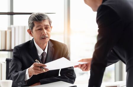 The young businessman sending the report to his boss on hand in the office room.の写真素材
