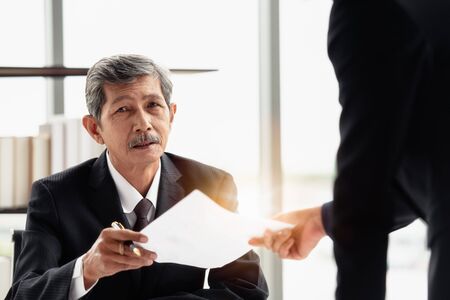 The young businessman sending the report to his boss on hand in the office room.の写真素材