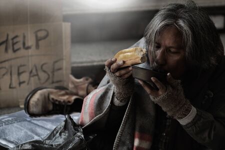 Homeless people living in various cities He waited and needed help from the kind people to give him all the necessary things, clothing, bread, water, and home. He is dirty and has no money with him.の写真素材