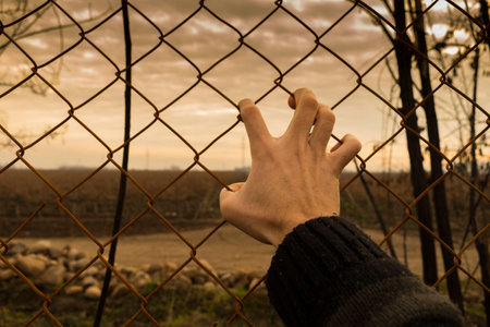 Hand holding fence.の写真素材