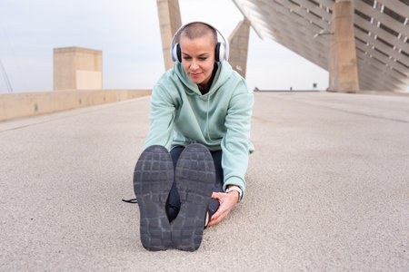 Smiling fit and active runner warming up stretching for running or cardio exercise.