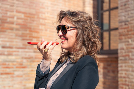 Beautiful caucasian business woman smiling talking on smartphone outdoors.の写真素材