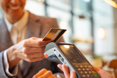 Close-up Unrecognizable female customer paying with contactless credit card in a restaurant.