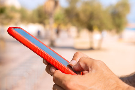 close up of young boy using smartphone app outdoors.