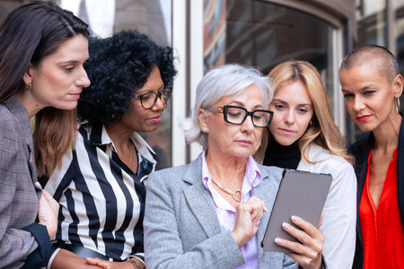 Team of led smiling multiracial businesswomen chatting with each otherの写真素材