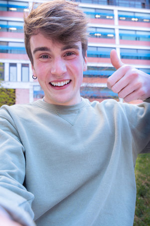A smiling young man with a smartphone outdoors.の写真素材