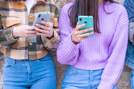 Unrecognizable students having fun with mobile phones creating content on social media.の写真素材