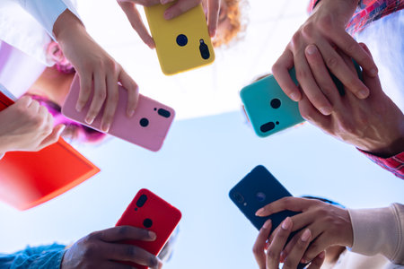 Group of people holding colorful smartphones in a circle