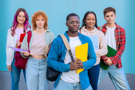 Group of serious diverse students on university campus holding notebooksの写真素材
