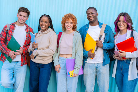 Group of smiling diverse students on university campus holding notebooksの写真素材