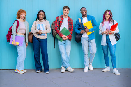 Group of smiling diverse students on university campus holding notebooksの写真素材