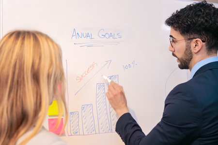 Businessman explaining growth chart during annual meeting at whiteboard