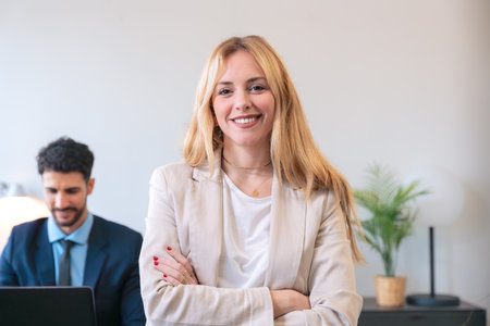 Confident businesswoman smiling with arms crossed in a modern office setting
