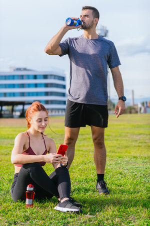 Young Couple Relaxing After Outdoor Workout in the Park.Verticalの写真素材