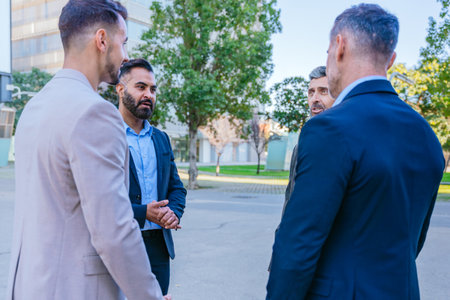 Businessmen Having a Discussion Outdoors in a Modern Cityの写真素材