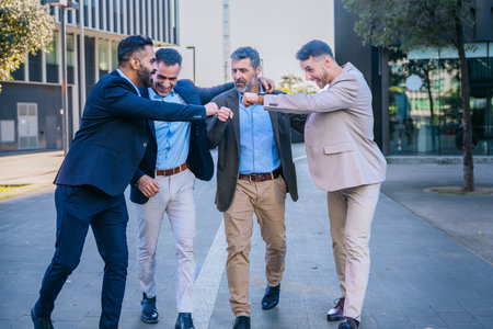 Businessmen celebrating with fist bumps outdoorsの写真素材