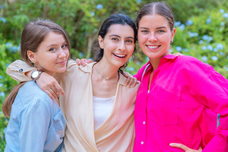 Three Happy Women Posing Together in a Green Parkの写真素材