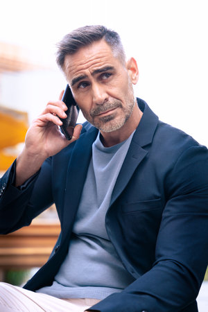 Confident Man Talking on Smartphone Outdoors in Urban Setting.の写真素材