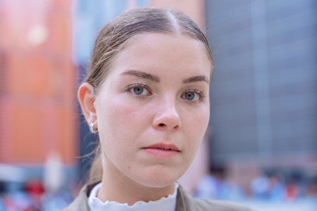 Serious Caucasian businesswoman looking at camera in modern corporate district.の写真素材