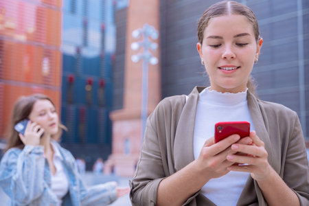 Young caucasian women using smartphones in modern urban city environmentの写真素材